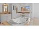 Bathroom featuring a large tub with gold hardware, a double sink vanity, and tile flooring at 608 Orange Ave, Clearwater, FL 33756