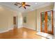 Bedroom featuring a ceiling fan, hardwood floors, and french doors to a balcony at 608 Orange Ave, Clearwater, FL 33756