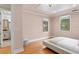 Bedroom with wood floors, white walls, and a bed, with a peek into the ensuite bathroom at 608 Orange Ave, Clearwater, FL 33756