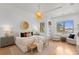 Bright bedroom features a decorative light fixture, wood floors, sitting area and large window at 608 Orange Ave, Clearwater, FL 33756