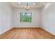 Dining room featuring hardwood floors, a chandelier, and a large window for natural light at 608 Orange Ave, Clearwater, FL 33756