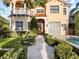 Elegant two-story home featuring a red tile roof, stucco exterior, and lush landscaping with a pristine pool at 608 Orange Ave, Clearwater, FL 33756