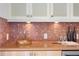 Close-up of modern kitchen with mosaic tile backsplash and a golden vessel sink at 608 Orange Ave, Clearwater, FL 33756