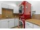 Modern laundry room with granite counters, white cabinets, and stacked red washer and dryer at 608 Orange Ave, Clearwater, FL 33756