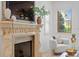 Bright living room featuring a decorative fireplace, chair and light stone floors at 608 Orange Ave, Clearwater, FL 33756