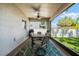 Screened-in patio furnished with a dining set, creating an inviting outdoor dining space with views of the backyard at 6318 S Harold Ave, Tampa, FL 33616