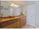 A cozy bathroom showing a wood vanity with granite countertop, a large mirror, and ample lighting at 6372 Palma Del Mar S Blvd # 1007, St Petersburg, FL 33715