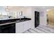 Modern kitchen features stainless steel sink, black appliances, white cabinets, and wood-style flooring at 6372 Palma Del Mar S Blvd # 1007, St Petersburg, FL 33715