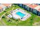 Aerial view of community pool featuring lounge chairs, tiki umbrellas, and well-manicured landscaping at 6372 Palma Del Mar S Blvd # 1007, St Petersburg, FL 33715