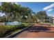 Community entrance sign surrounded by lush landscaping and well-maintained brick road, creating a welcoming atmosphere at 6826 Stones Throw N Cir # 11104, St Petersburg, FL 33710