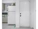 Kitchen entrance, featuring light tile flooring, a white refrigerator, and wood cabinets at 6826 Stones Throw N Cir # 11104, St Petersburg, FL 33710