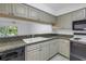 Galley kitchen featuring dark countertops, stylish wood cabinets, and a double basin sink at 6826 Stones Throw N Cir # 11104, St Petersburg, FL 33710