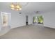 Bright living room with carpet flooring, sliding glass doors to the porch, and neutral wall paint at 6826 Stones Throw N Cir # 11104, St Petersburg, FL 33710