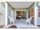Covered and tiled patio with white chairs overlooking mature landscaping at 6826 Stones Throw N Cir # 11104, St Petersburg, FL 33710