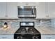 Stainless steel gas range with white shaker cabinets and subway tile backsplash at 7510 Lantern Park Ave, Apollo Beach, FL 33572