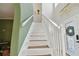 Bright white staircase with carpeted treads and decorative lighting fixture near front door at 7551 141St St, Seminole, FL 33776