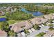 Aerial view showcasing real estate property near a pond, greenery, and neighborhood homes at 767 Tremont Greens Ln # 64, Sun City Center, FL 33573