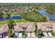 An aerial view exhibits a home complemented by lush greenery and water features nearby at 767 Tremont Greens Ln # 64, Sun City Center, FL 33573
