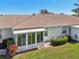 The home's exterior highlights a screened in patio, lush lawn and manicured shrubbery at 767 Tremont Greens Ln # 64, Sun City Center, FL 33573