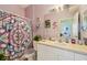 Bathroom with a unique floral shower curtain and pastel purple walls at 767 Tremont Greens Ln # 64, Sun City Center, FL 33573