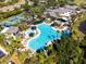 Aerial view of a large, inviting community pool surrounded by palm trees and lounge chairs at 767 Tremont Greens Ln # 64, Sun City Center, FL 33573