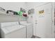 Bright laundry room with washer, dryer, shelving, and a door to the outside at 767 Tremont Greens Ln # 64, Sun City Center, FL 33573