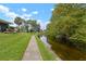 Scenic backyard view with a walking path along the canal and lush greenery at 7737 Eureka Dr # 203, Hudson, FL 34667