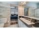 Bright bathroom featuring a double sink vanity with black countertop and ensuite view of the bedroom at 800 Druid S Rd, Clearwater, FL 33756