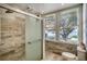 Bright bathroom featuring a shower, toilet, and a sunny window with a view at 800 Druid S Rd, Clearwater, FL 33756