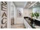 Bright bathroom featuring a double sink vanity with black countertop and stylish driftwood decorations at 800 Druid S Rd, Clearwater, FL 33756