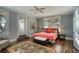 Bedroom with hardwood floors, ceiling fan, sunny windows, and a decorative area rug at 800 Druid S Rd, Clearwater, FL 33756