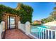 Inviting pool area featuring a brick patio, ivy-covered walls, and scenic waterfront views at 800 Druid S Rd, Clearwater, FL 33756