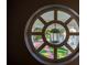 View from a round window to a quaint courtyard with garden path and lantern at 800 Druid S Rd, Clearwater, FL 33756