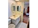 Bathroom with a white tiled floor, sink with vanity, oval mirror and floral wallpaper at 8100 Dr Martin Luther King Jr N St # 302, St Petersburg, FL 33702
