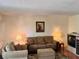 Cozy living room with a tan sofa and armchair, a floral rug, lamps and decorative art at 8100 Dr Martin Luther King Jr N St # 302, St Petersburg, FL 33702