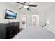 Bedroom featuring hardwood floors, a ceiling fan, a television, and a view of an adjacent dining room at 8128 Candlwoode Dr, Largo, FL 33773