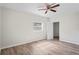 Comfortable bedroom with hardwood floors, a ceiling fan, and a window providing natural light and outdoor views at 8725 N Boulevard, Tampa, FL 33604