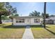 Charming single-story home featuring a well-manicured lawn, concrete walkway, and bright exterior paint at 8725 N Boulevard, Tampa, FL 33604