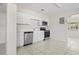 Functional kitchen with white cabinetry, stainless steel appliances, and a tiled floor for a clean look at 8725 N Boulevard, Tampa, FL 33604