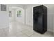 Open concept kitchen area featuring a black refrigerator, tiled flooring, and seamless transition to other spaces at 8725 N Boulevard, Tampa, FL 33604