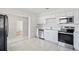 Well-lit kitchen featuring white cabinets, stainless steel appliances, and tiled flooring for easy maintenance at 8725 N Boulevard, Tampa, FL 33604