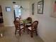 Cozy dining area with a glass-top table and four rattan chairs, illuminated by a pendant light at 10034 64Th N Ave # 11, St Petersburg, FL 33708