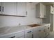 White cabinets with granite countertops, undermount sink, and modern black handles at 10636 Crescent Creek Xing, Parrish, FL 34219