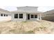 Rear exterior view of home featuring an open porch, light gray exterior, and large windows at 10644 Crescent Creek Xing, Parrish, FL 34219