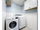 Well-lit laundry room with washer, dryer, and storage shelves at 12636 95Th N St, Largo, FL 33773