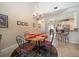 Cozy dining area features an elegant chandelier and bar top view into the modern kitchen at 13208 San Blas Loop, Largo, FL 33774