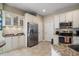 Well-lit kitchen with stainless steel refrigerator, granite countertops and white cabinets at 13208 San Blas Loop, Largo, FL 33774