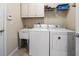 Functional laundry room with a washer, dryer, sink, and storage cabinets at 13208 San Blas Loop, Largo, FL 33774