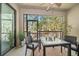 Relaxing screened patio with table and chairs that offers a beautiful view of the lush landscaping at 13208 San Blas Loop, Largo, FL 33774