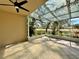 Spacious screened patio with tiled flooring, ceiling fan, and views of the beautifully landscaped backyard at 13526 Norman Cir, Hudson, FL 34669